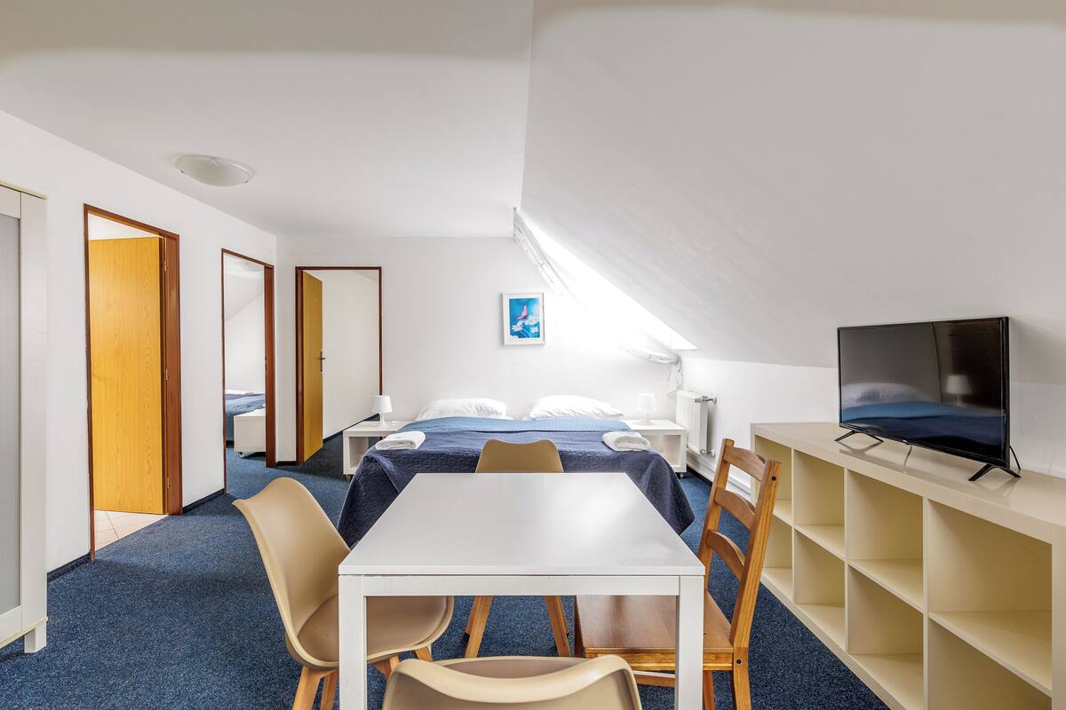 Une chambre d’hôtel avec un lit, une télévision, un bureau et des chaises.