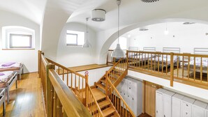 A room with a wooden staircase, bunk beds, and lockers. - Hotel Stary Pivovar (Prague)