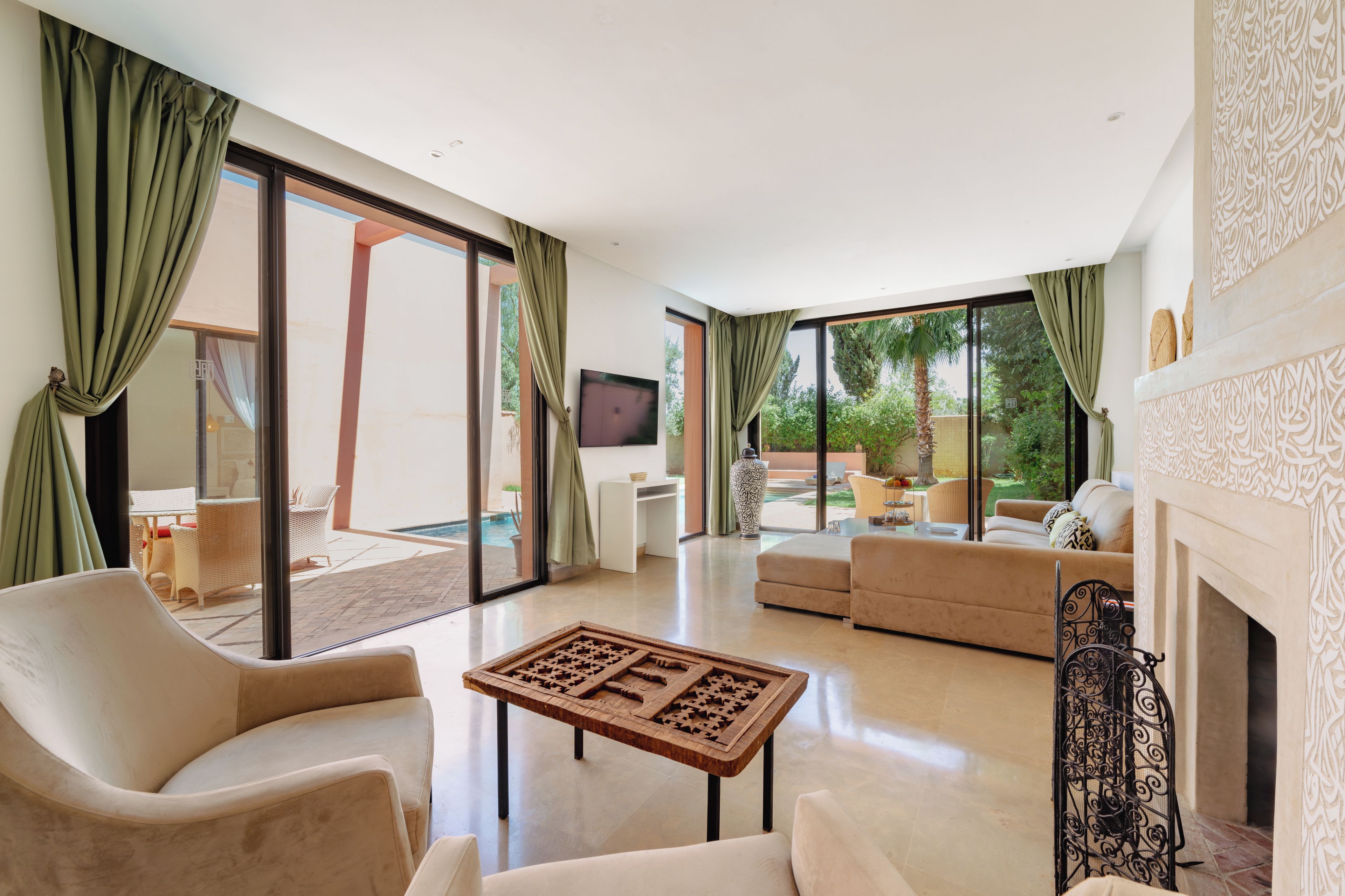 Un amplio salón con chimenea, ventanas grandes y vistas al exterior.