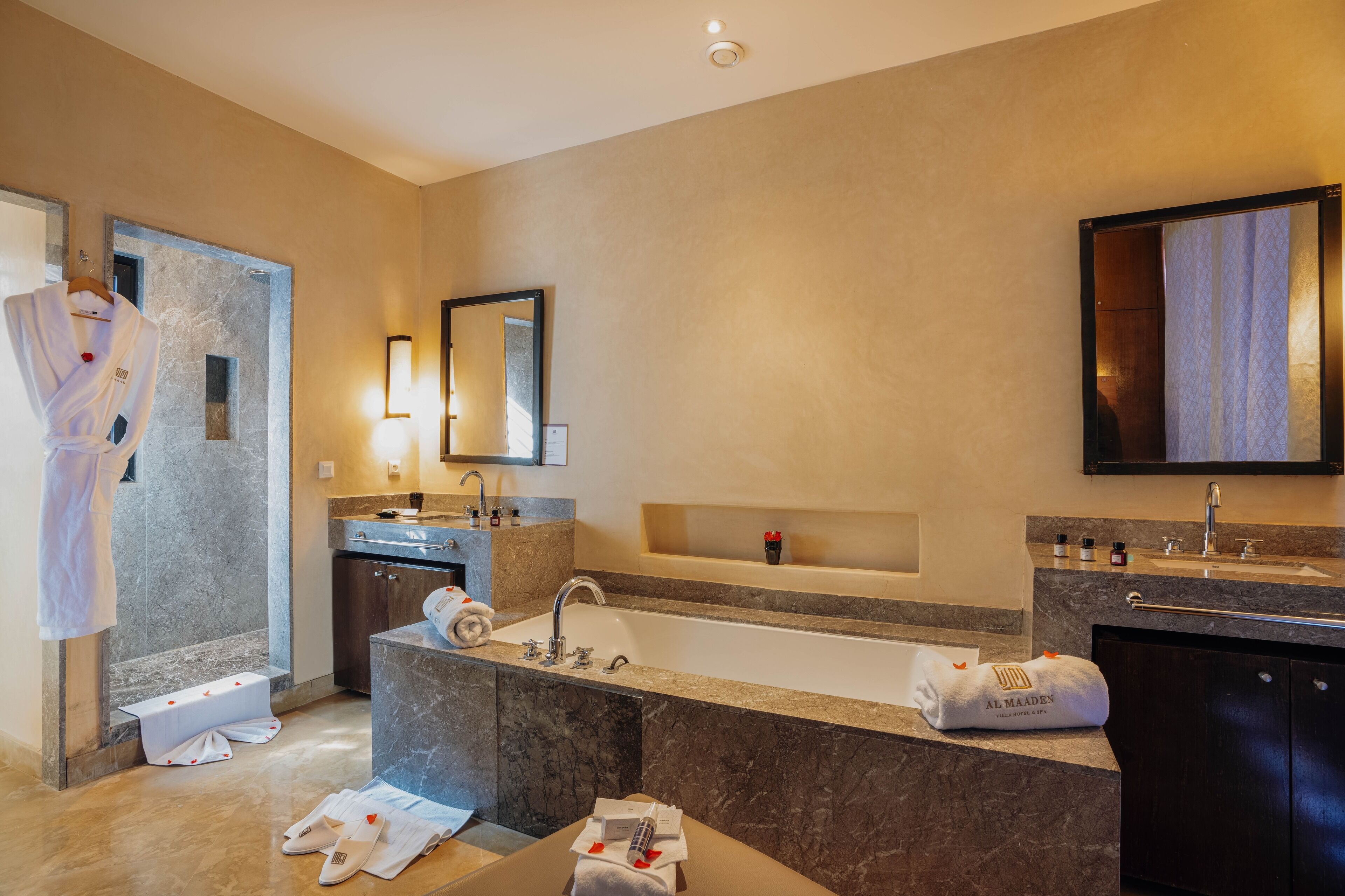 A modern bathroom with a bathtub, a large mirror, a vanity with a sink, and a shower area.