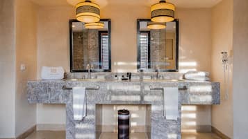 A bathroom with two sinks, a large mirror, and a towel rack.