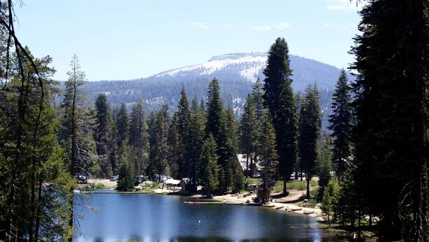 Un lago rodeado de árboles y una montaña al fondo.