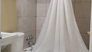Een badkamer met bad, toilet en wastafel.