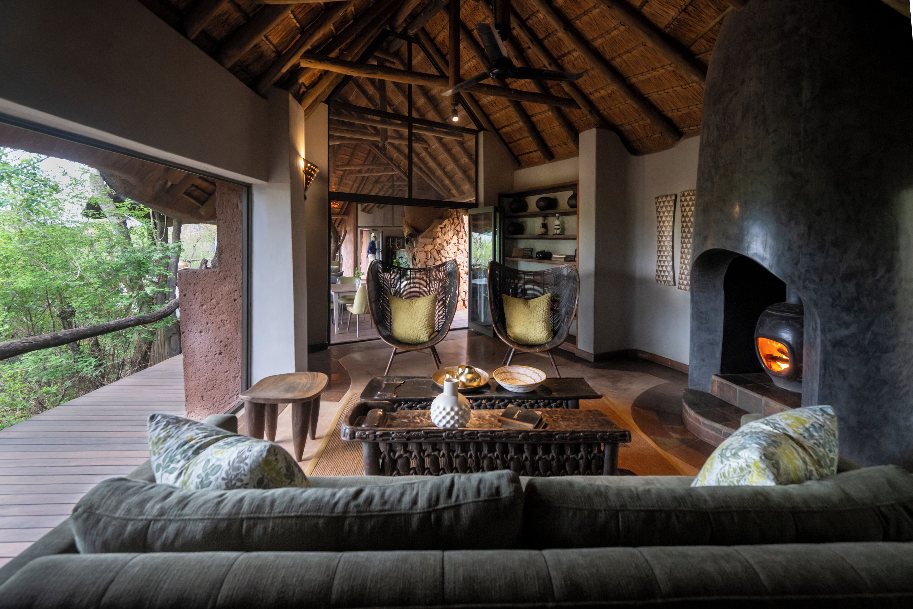 Un interior acogedor con techo de madera, chimenea de piedra y vistas al exterior.