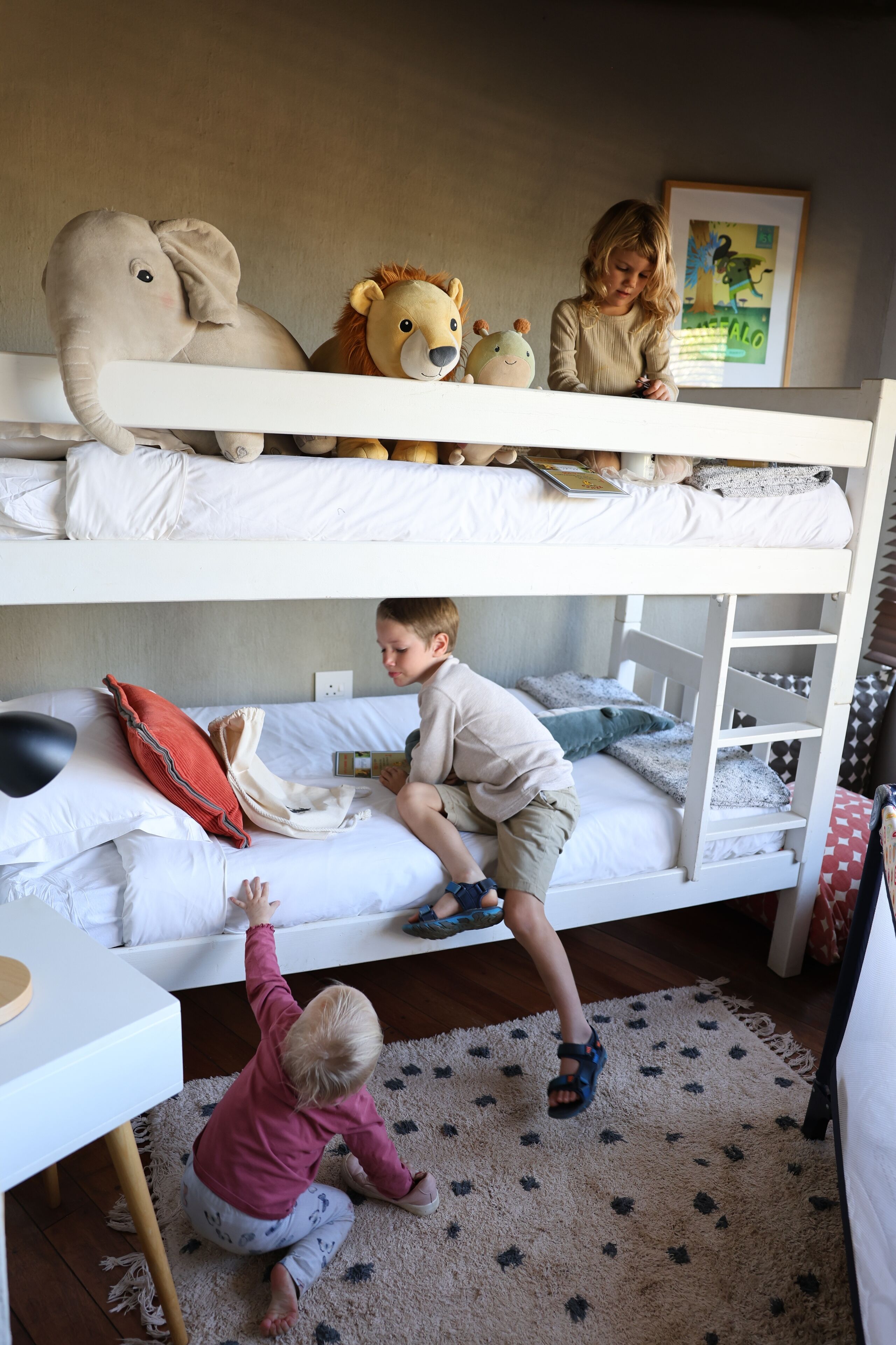 Habitación con literas, un niño en la cama inferior y otro en la superior.