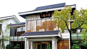 A traditional building with a tiled roof and a sign in a foreign language. - Garden Hotel (Suzhou)
