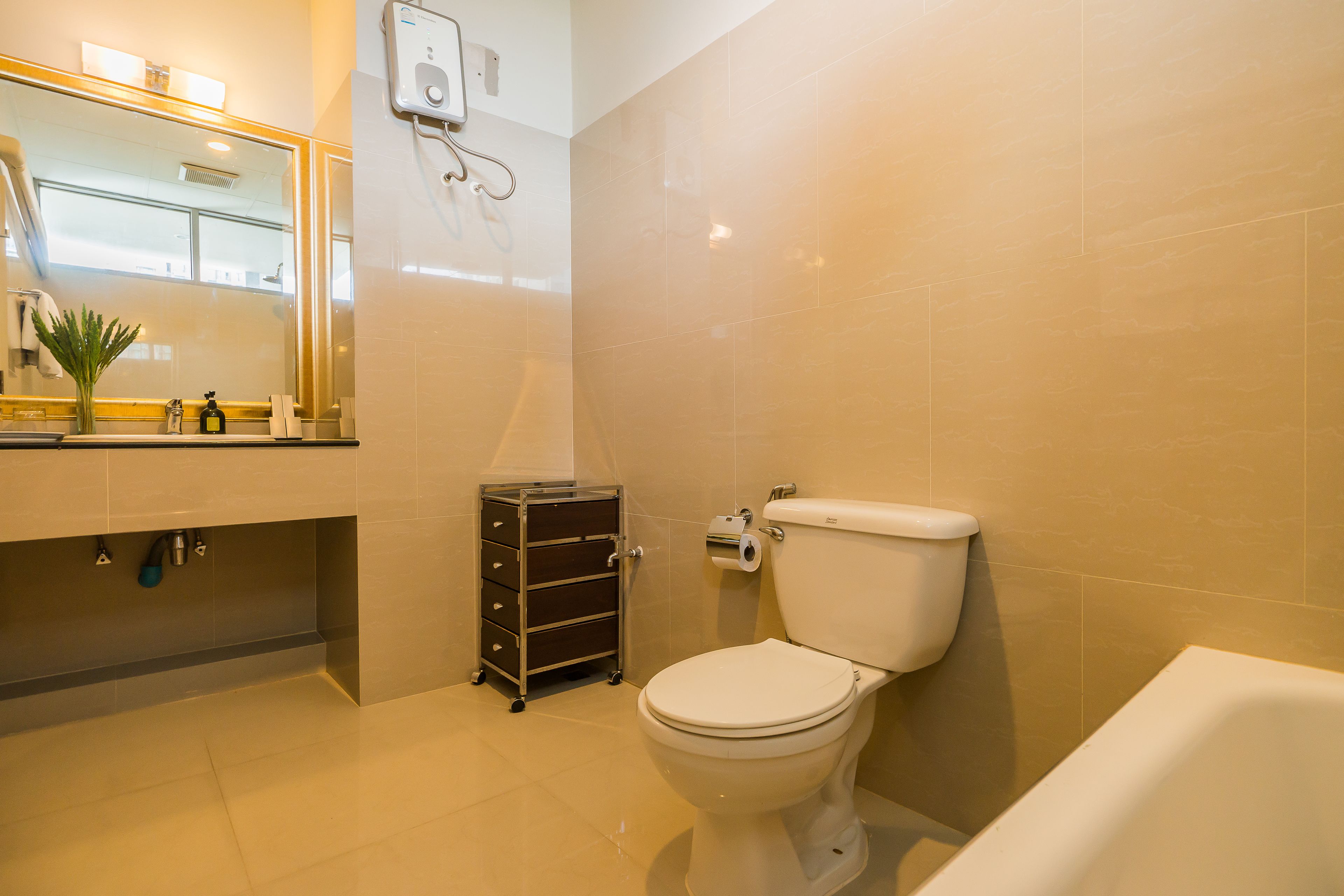 Une salle de bain avec des toilettes, un lavabo et un petit meuble de rangement.