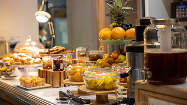 A buffet with various food items and a beverage dispenser.