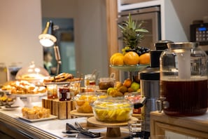 A buffet with various food items and a beverage dispenser.