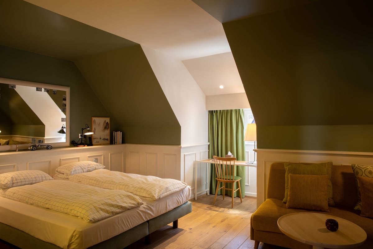 Un dormitorio con cama, escritorio y silla.