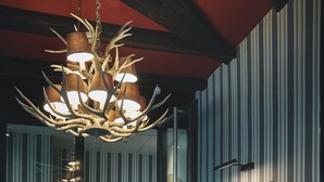 A modern interior with a chandelier, striped walls, and a framed portrait.