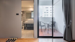 Um interior moderno com uma porta de vidro deslizante que dá para uma varanda com vista para a cidade.