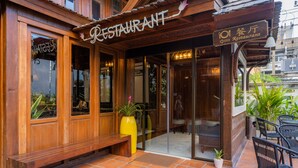 Fachada de madeira de um restaurante com uma placa indicando o nome.