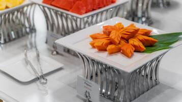 A buffet with various fruits and a sign indicating 'Papaya'.