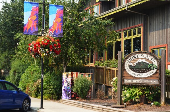 Un edificio de madera con un letrero que dice "Howe Sound Inn & Brewing Company" y una maceta con flores.