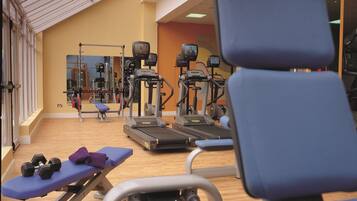 A gym with exercise equipment, a treadmill, and a bench.
