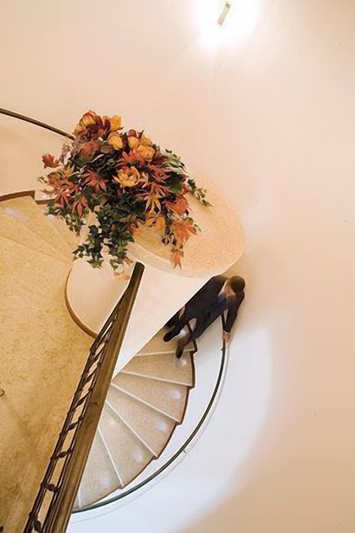 En spiraltrappa med en blomsterdekoration högst upp.