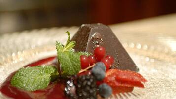 A dessert with berries and mint leaves on a plate.