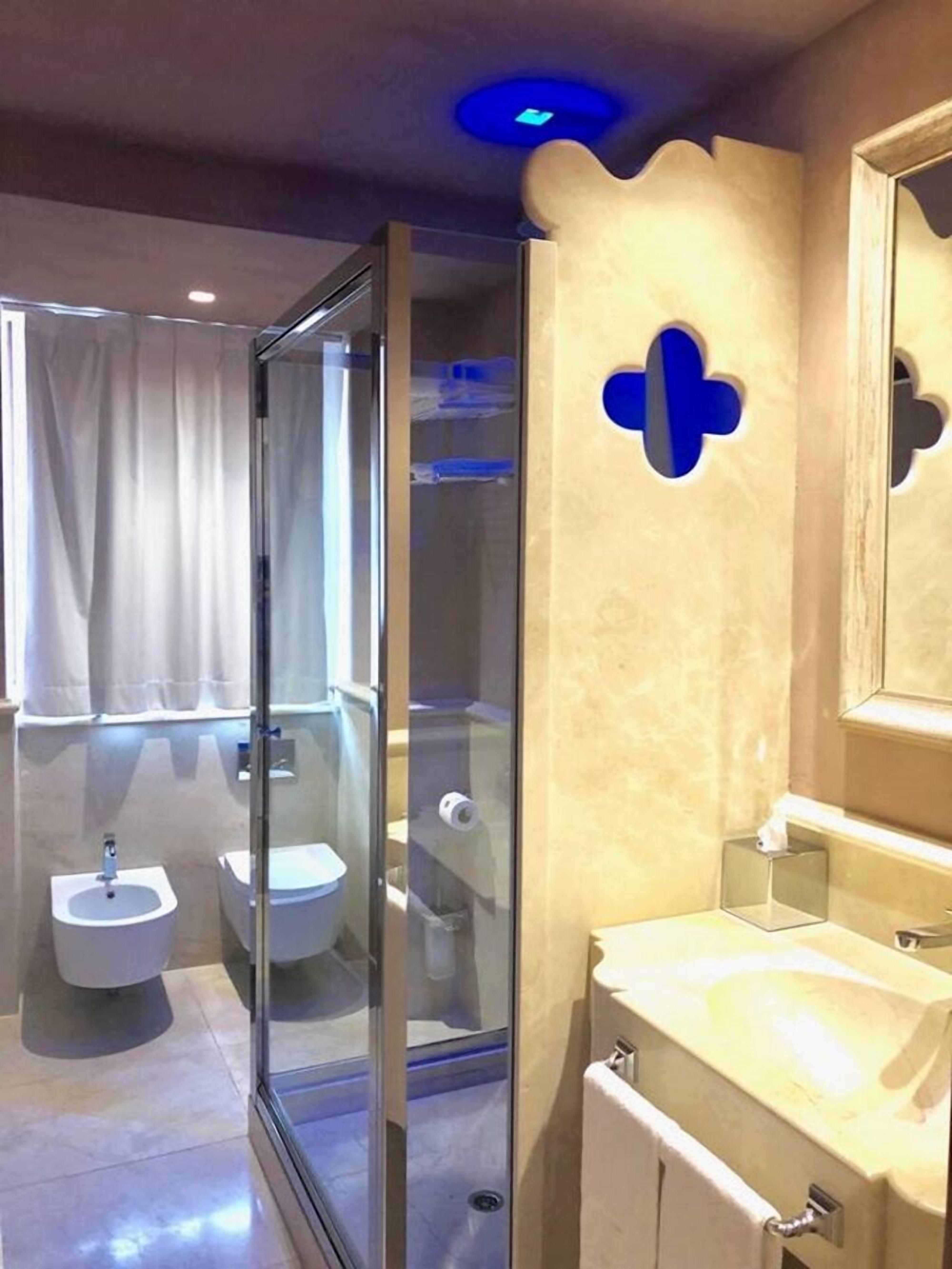 Ein modernes Badezimmer mit Duschkabine aus Glas, einem Bidet, einer Toilette und einem Waschbecken.