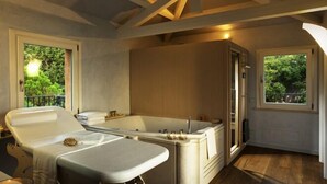 Une salle de bain moderne avec une baignoire sur pieds, un meuble-lavabo et une grande fenêtre offrant une vue sur la verdure.