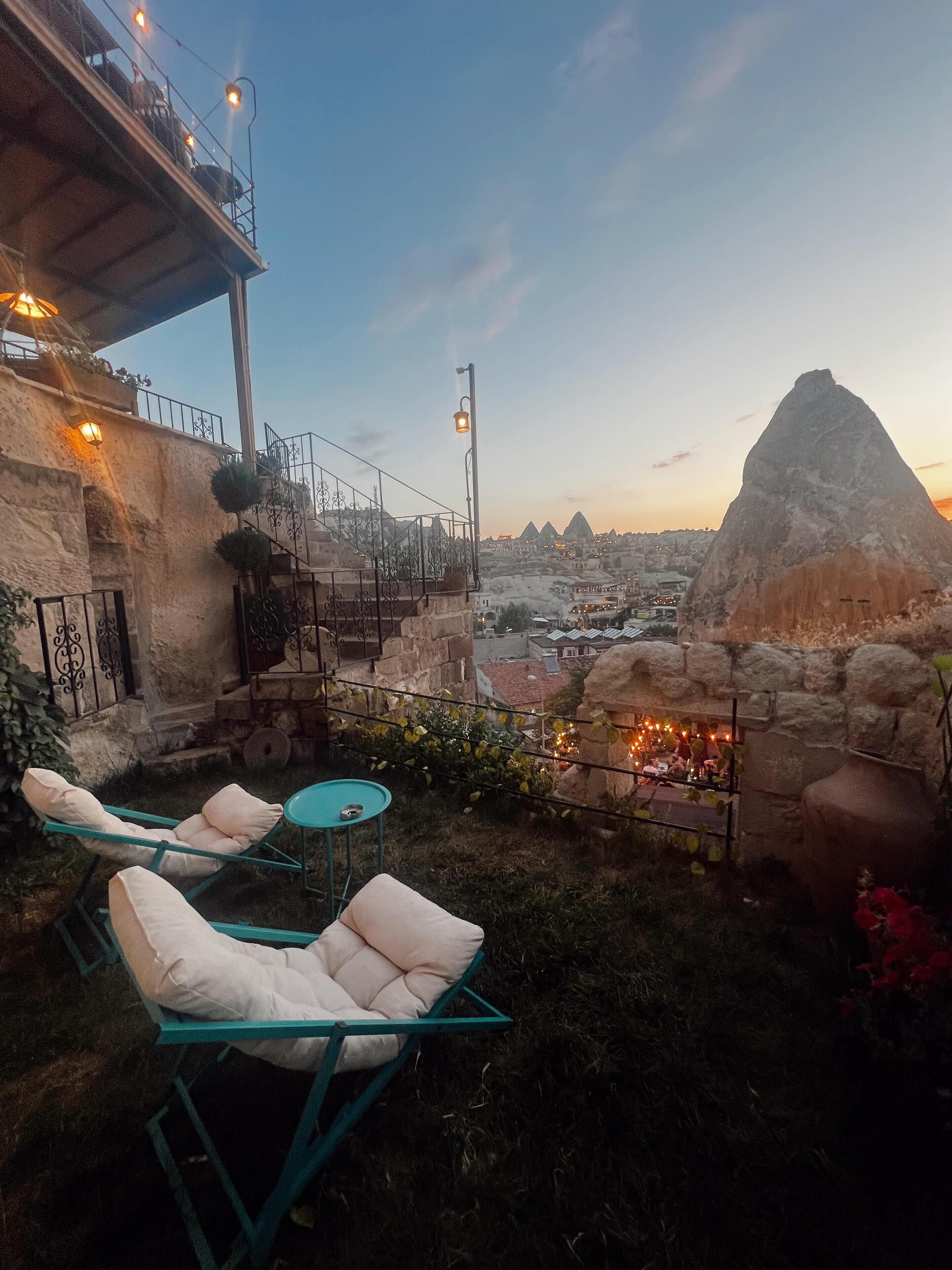 A terrace with outdoor seating and a view of a mountain.