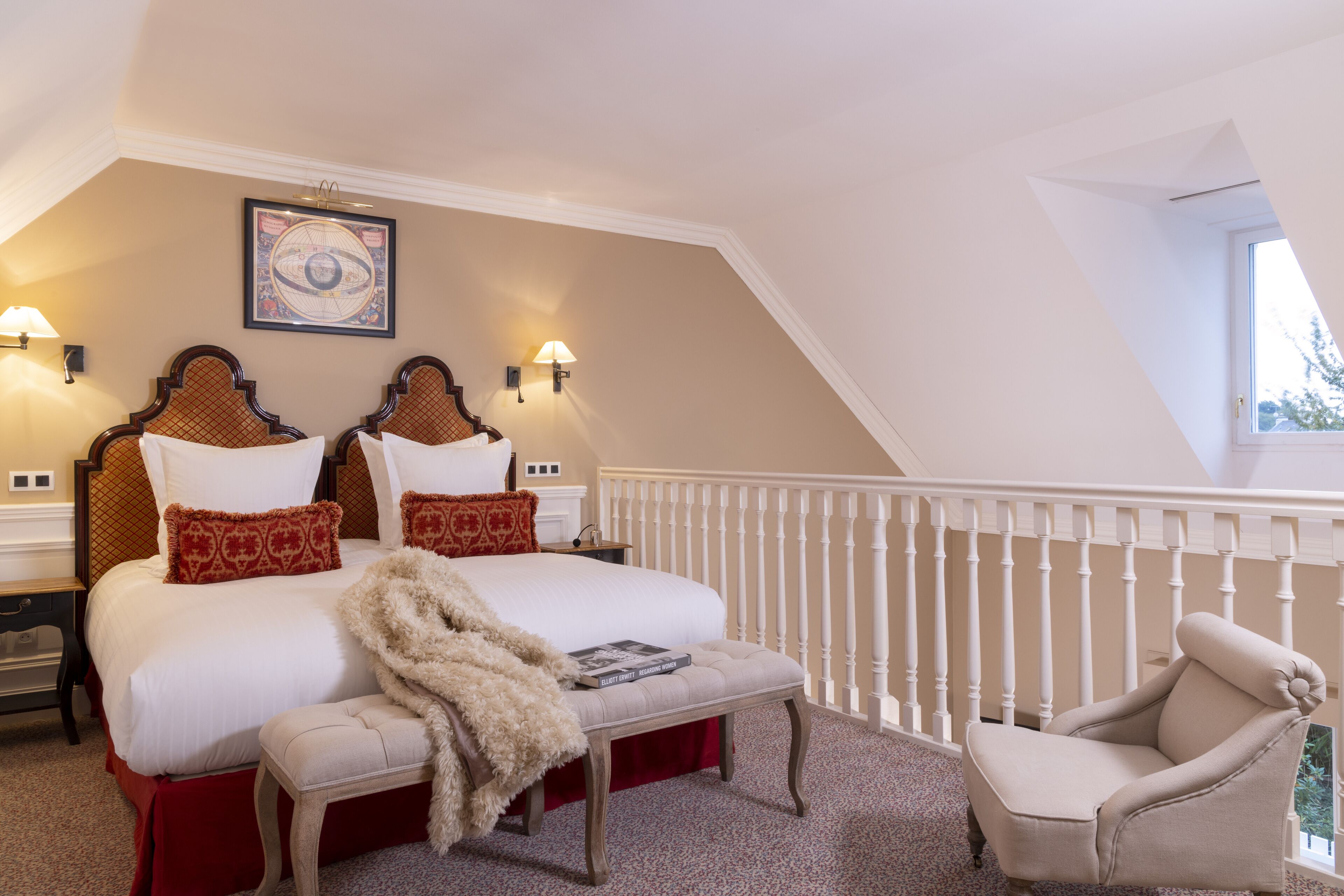 A bedroom with a large bed, two bedside tables, a chair, and a window.