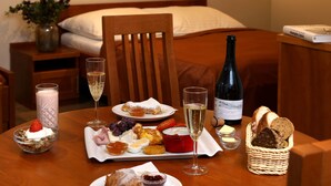 A breakfast setting with a variety of foods, drinks, and a bottle of wine on a wooden table. - Andel Apartments Praha (Prague)