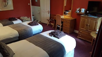 A hotel room with two beds, a desk, a dresser, a mirror, and a television.