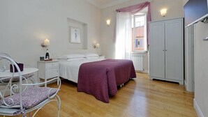A bedroom with a bed, bedside table, lamp, and wardrobe. - Amaranto Romano (Rome)