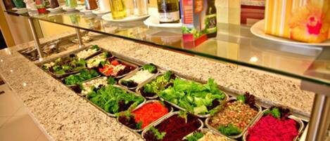 A buffet with various food items and condiments.