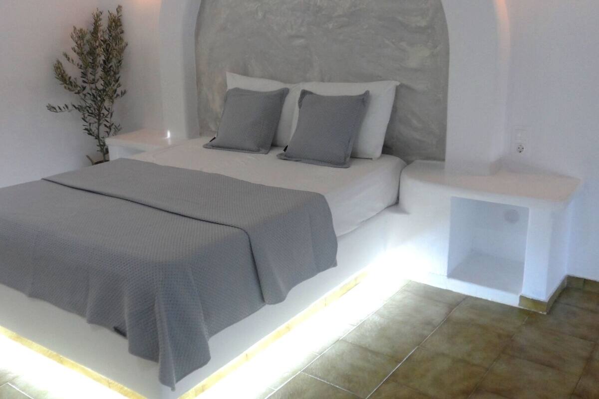 A modern bedroom with a bed, bedside tables, and a nightstand.