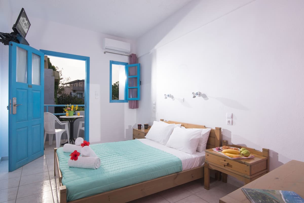 A bedroom with a bed, bedside table, and a desk with a chair.