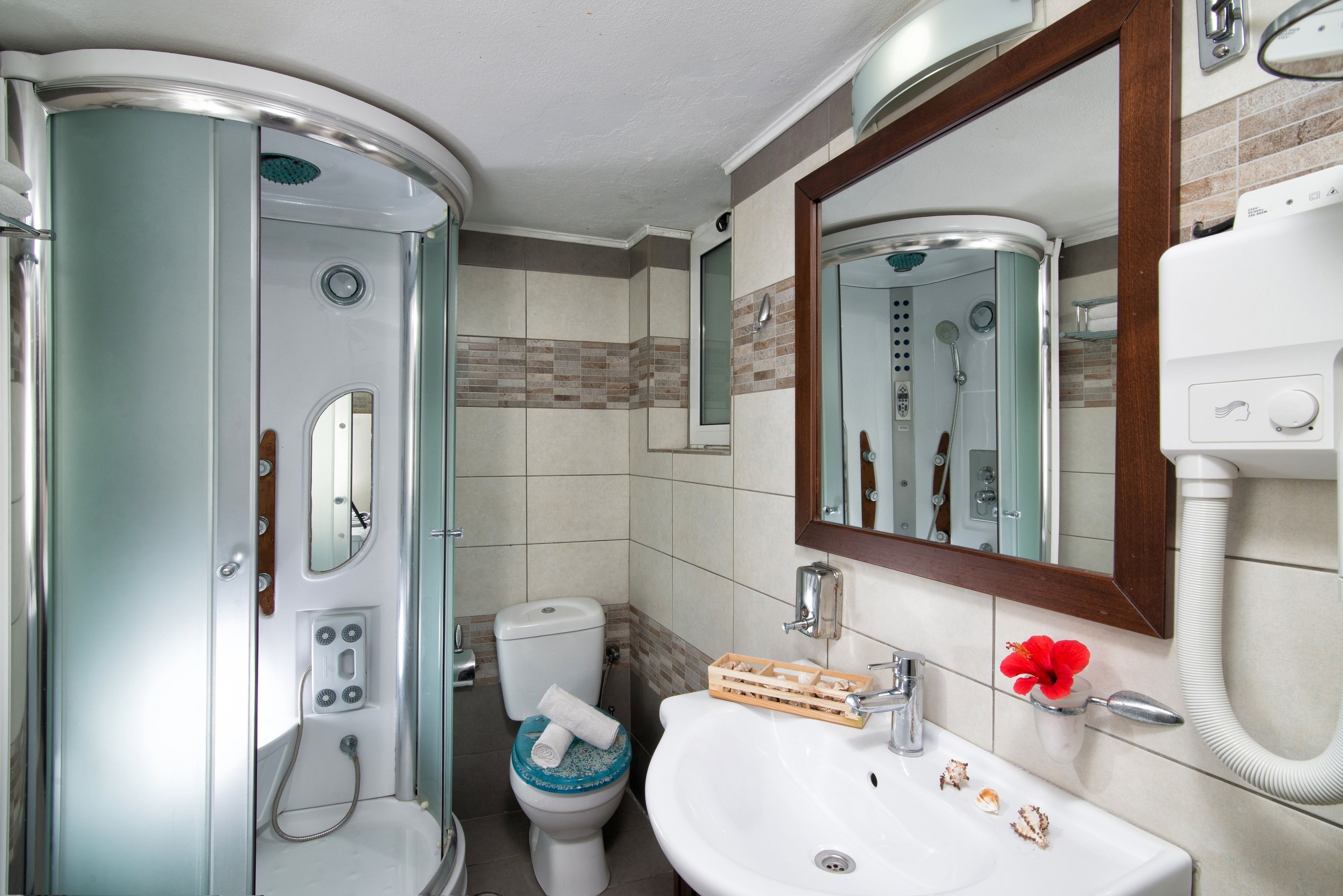 Une petite salle de bain comprenant une douche, des toilettes et un lavabo.
