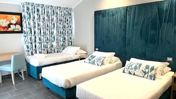 Ein Hotelzimmer mit zwei Einzelbetten, einem Schreibtisch und einem Stuhl.