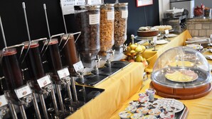 A buffet setup with various food options including cereal, fruits, and yogurt.
