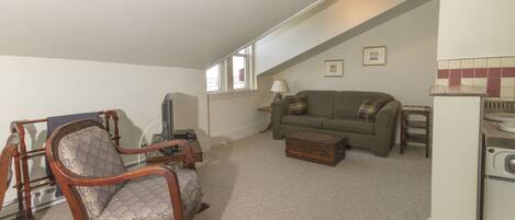 A living room with a rocking chair, a sofa, a small table, and a washing machine.