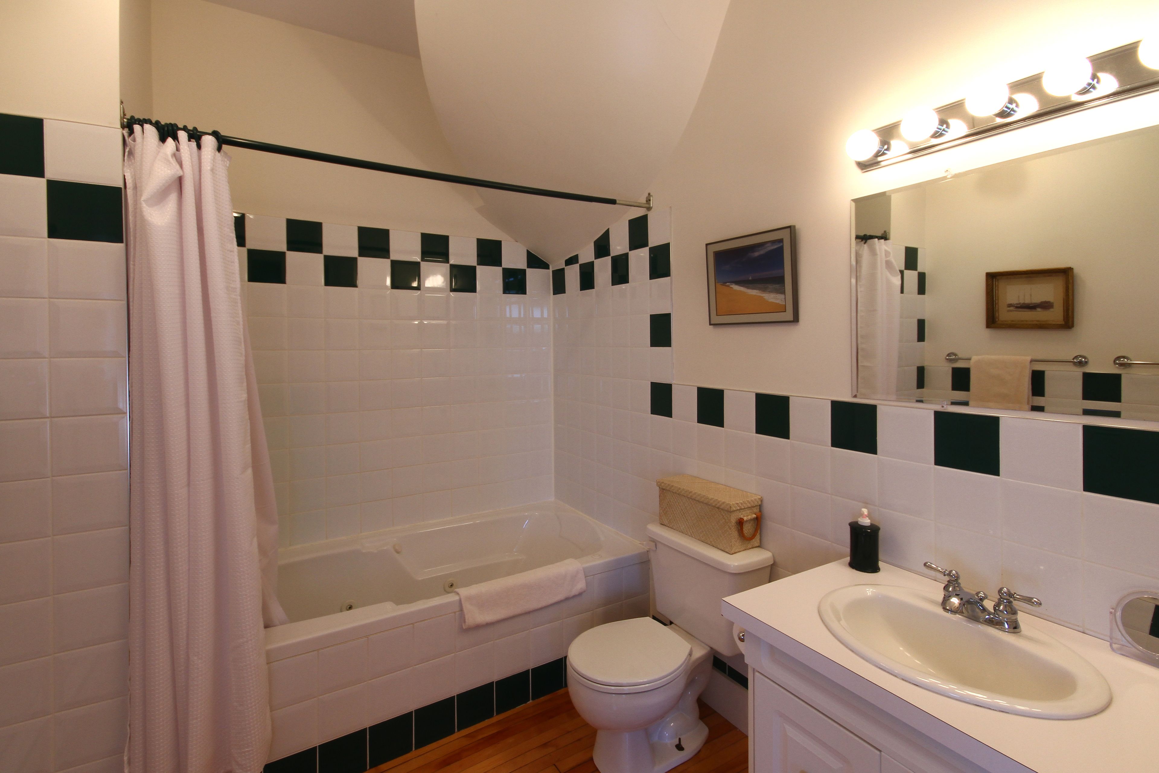 Un baño con bañera, inodoro y lavamanos.