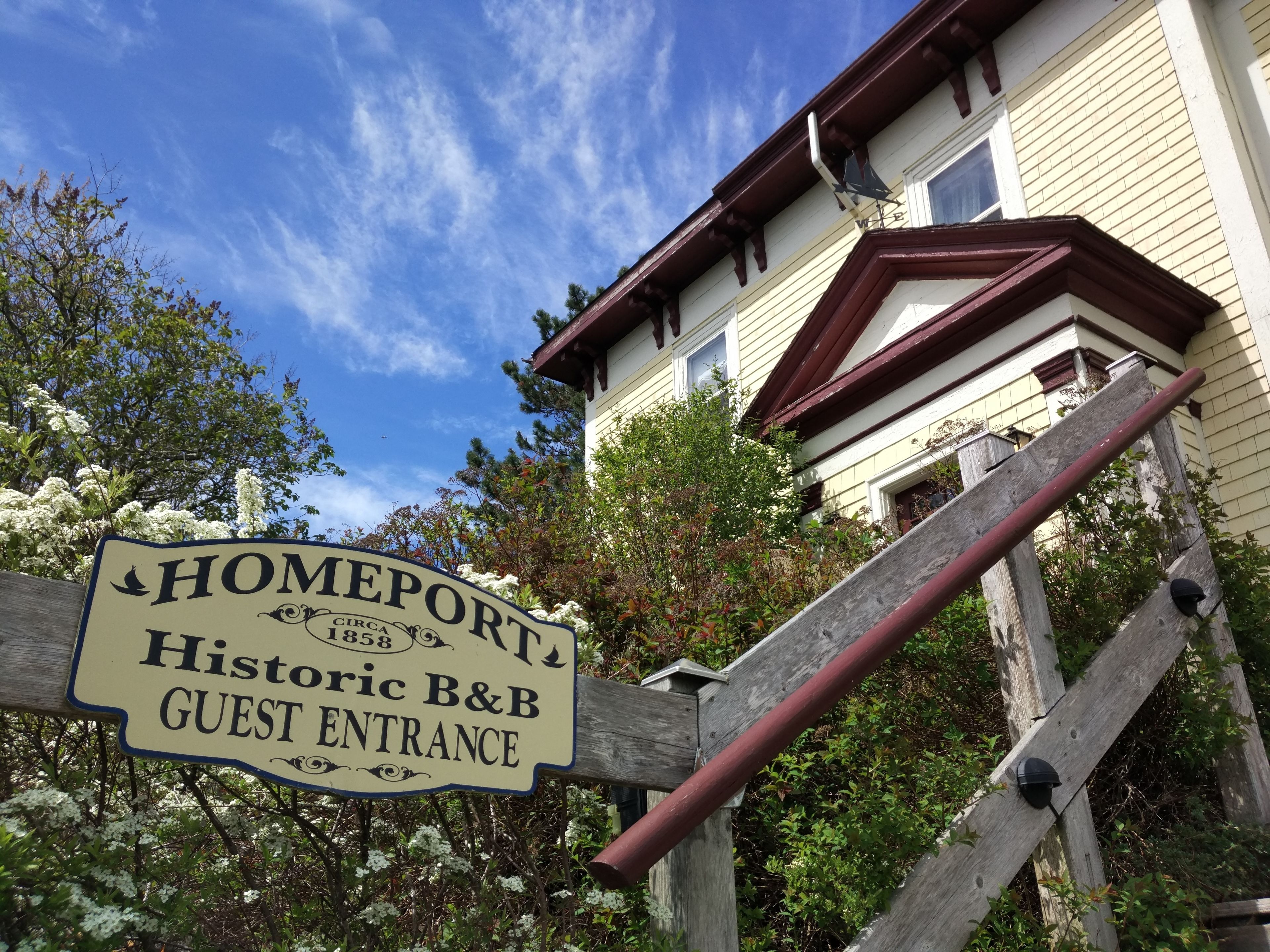 A wooden sign with "HOMEPORT Historic B&B GUEST ENTRANCE" and "CIRCA 1858" text.
