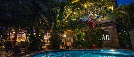 Una piscina al aire libre, sillones reclinables de piscina