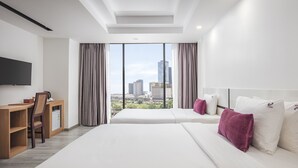 Une chambre d’hôtel avec deux lits, un bureau et une télévision.