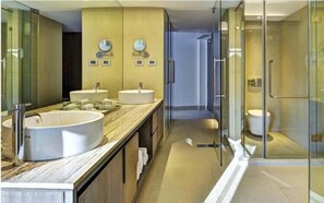 A modern bathroom with two sinks, a large mirror, and a glass shower enclosure. - Avasa Hotel (Hyderabad)