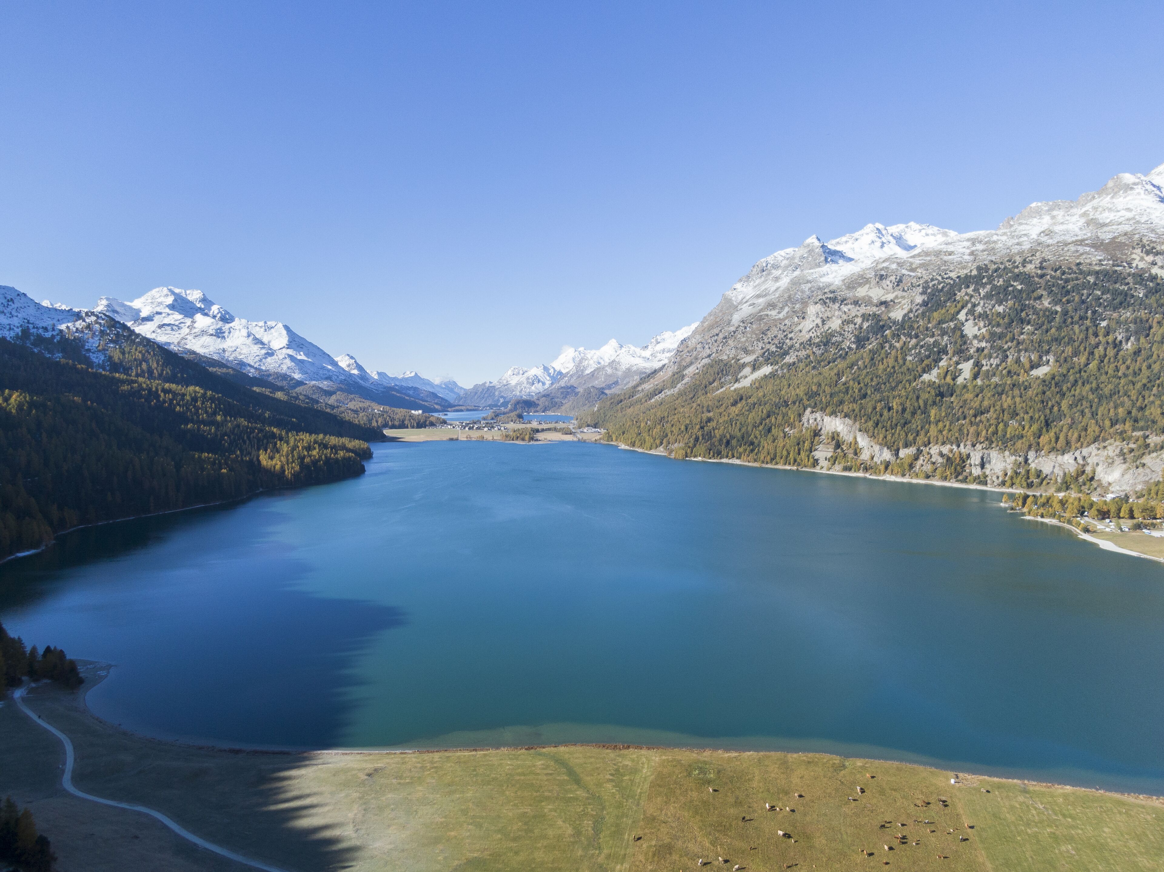 A large lake surrounded by mountains and forests.