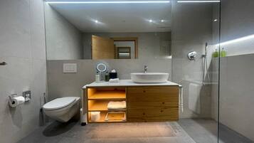 A modern bathroom with a toilet, sink, and shower.