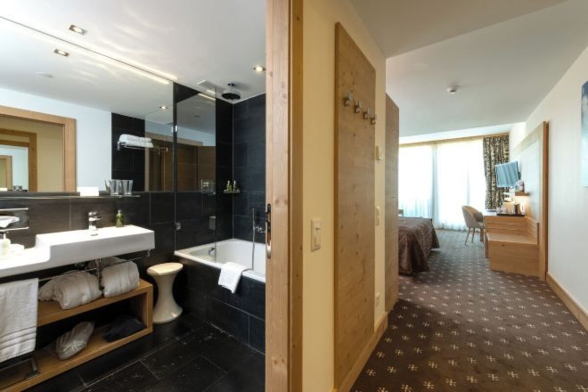 Een moderne badkamer met een badkuip, toilet en wastafel.