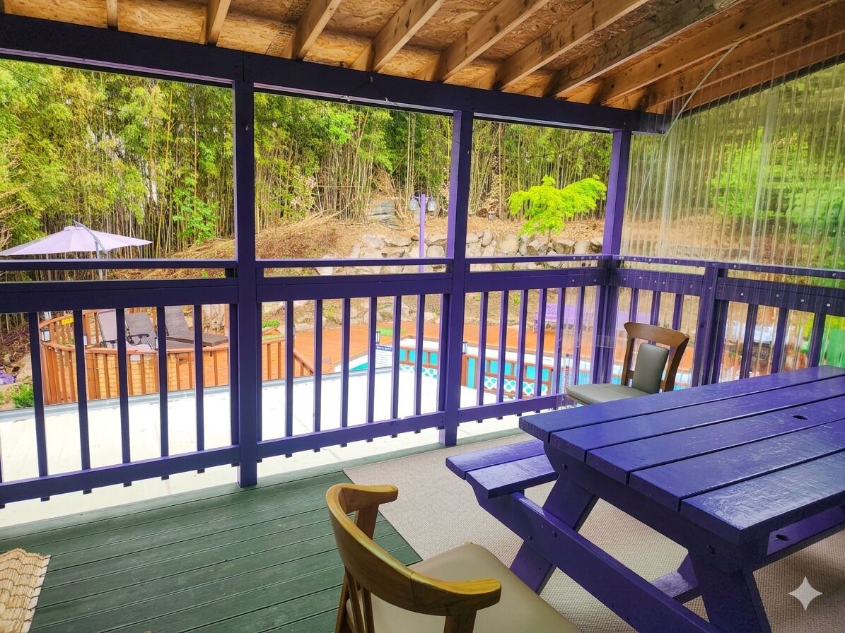 Un espace extérieur abrité, doté d’une terrasse en bois, d’une piscine et offrant une vue sur une forêt.