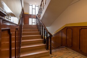 A grand staircase with wooden railings and a polished floor, leading to an upper level.