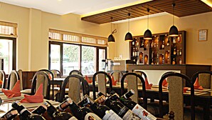 A restaurant with a bar area, wooden chairs, and tables set for dining. - Hotel Thamel (Kathmandu)