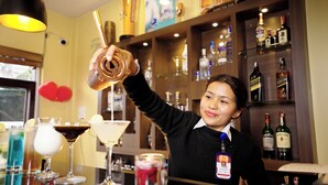 A bar area with various bottles and glasses, including a martini glass and a cocktail with a lemon slice. - Hotel Thamel (Kathmandu)
