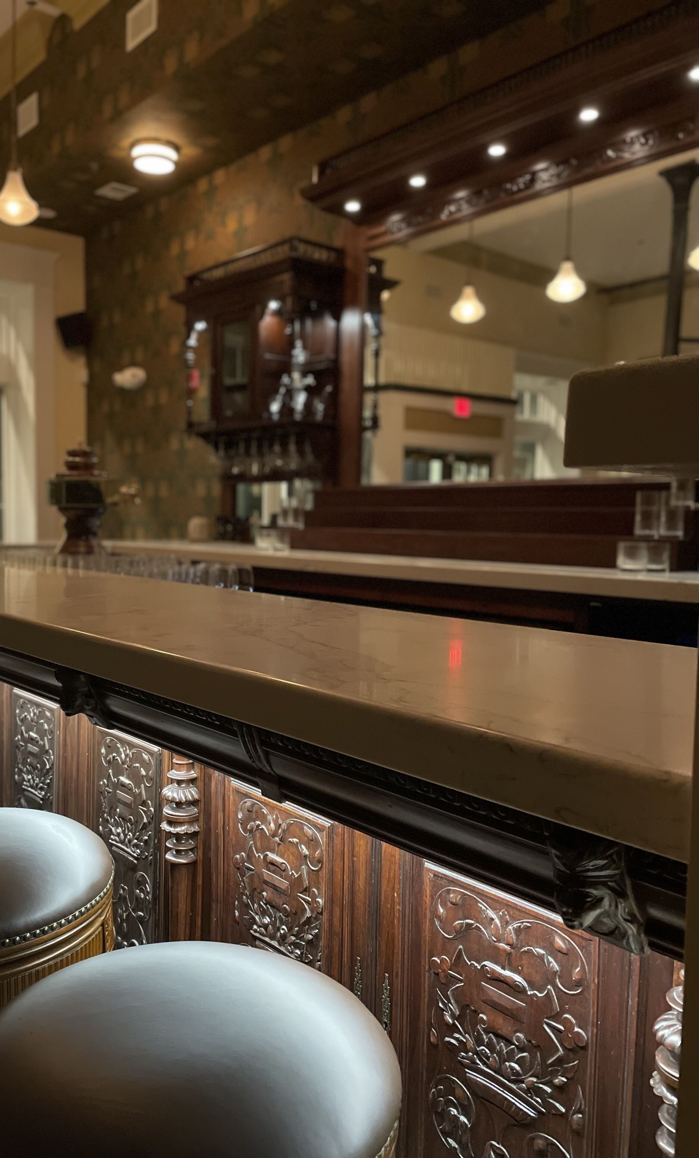 A bar area with a wooden counter and bar stools.