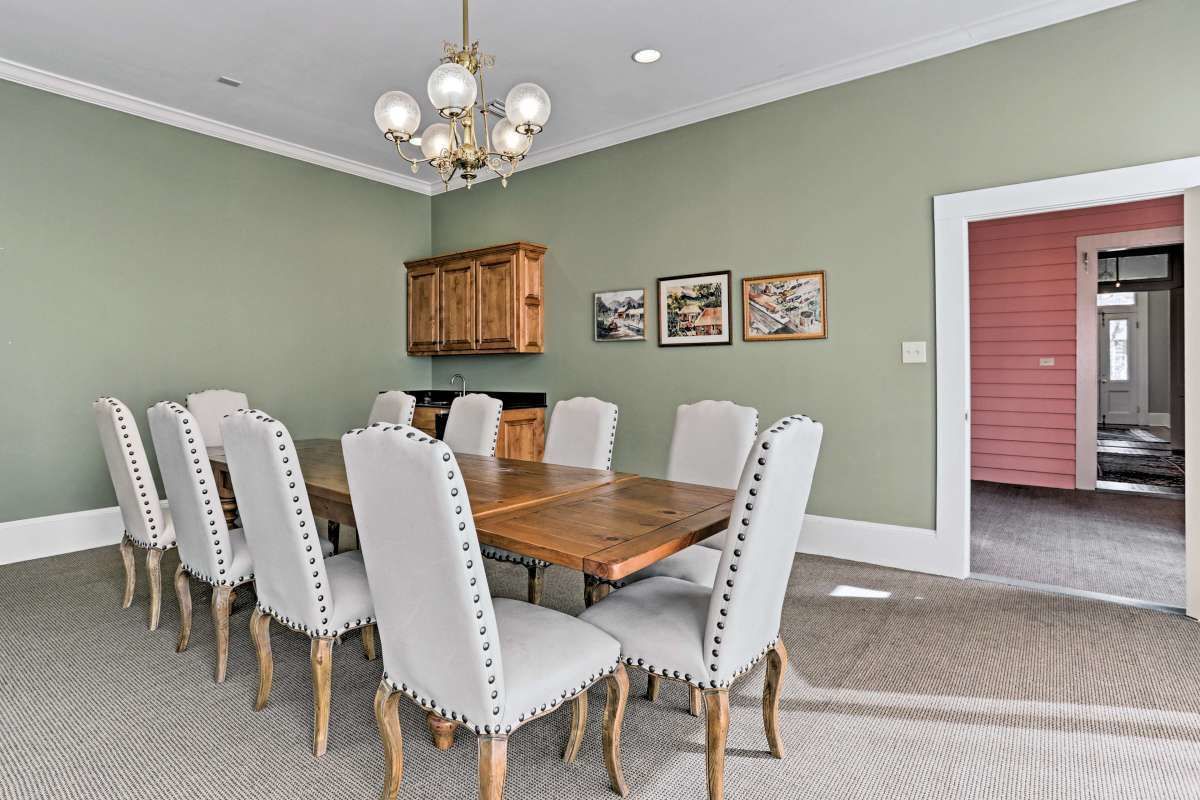 Comedor con mesa de madera y seis sillas tapizadas con tachuelas de metal.